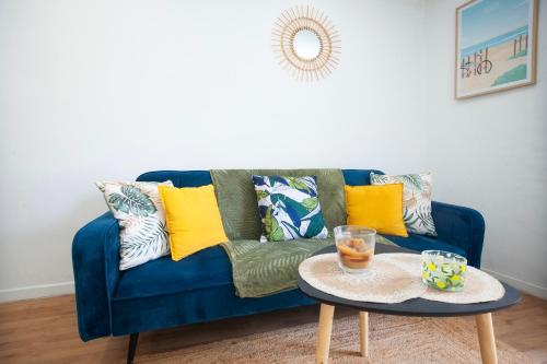 un canapé bleu avec des oreillers colorés et une table dans l'établissement Cosy et moderne, centre-ville, à La Ciotat