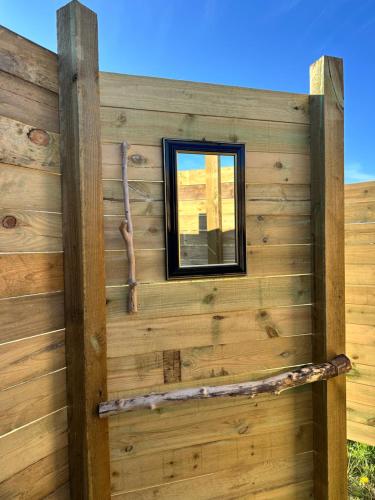a window on the side of a wooden wall at Big tent with real beds and ocean view in Stege
