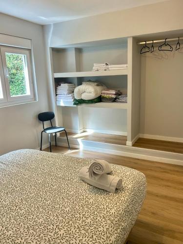 a bedroom with a bed and a chair and shelves at El sueño de Verónica in Cudillero