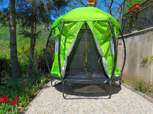 a green tent with a chair in a garden at Villa Evetes in Jablonov nad Turnou