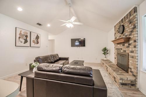 a living room with a leather couch and a fireplace at Family friendly home in DFW area in Watauga