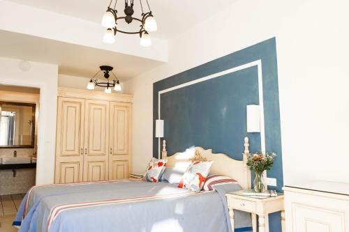 a bedroom with a bed with a large blue wall at Pelican Hotel in Mýkonos City