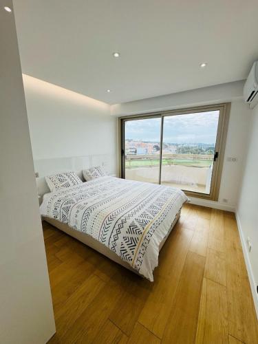 une chambre avec un lit et une grande fenêtre dans l'établissement Beautiful apartment stunning view of the Lion de Mer, à Saint-Raphaël