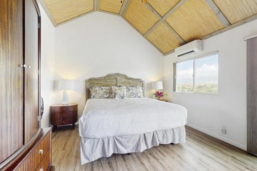 a bedroom with a bed and a large window at Waikoloa Views in Waikoloa Village