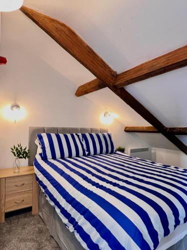 a bedroom with a blue and white striped bed at Little Dockray Two-Bedroom Apartment Centre of Penrith in Penrith