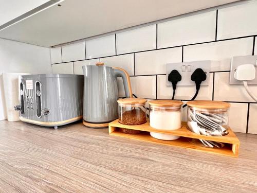 a kitchen counter with various appliances on a shelf at Little Dockray Two-Bedroom Apartment Centre of Penrith in Penrith