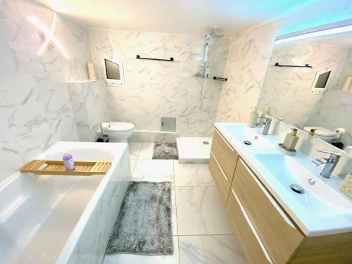 une salle de bain avec une baignoire, un lavabo et des toilettes dans l'établissement Villa Oscar, au Cannet