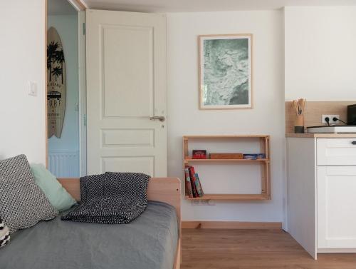 a living room with a couch and a kitchen at L'Olivier, appartement cosy entre mer et forêt in Saint-Michel-Chef-Chef