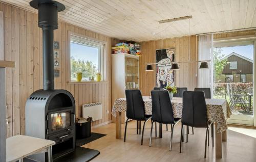 a living room with a fireplace and a table and chairs at Holiday Home Sommerstedvej Denm in Vinderup