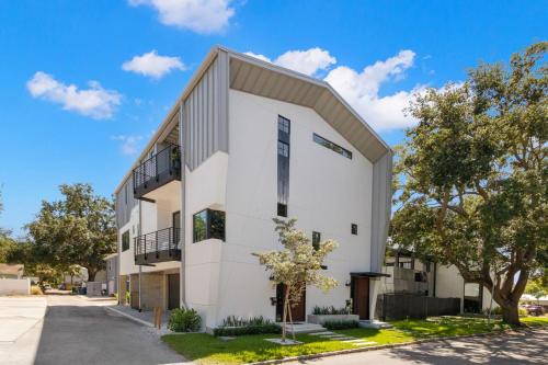 a white building with a gambrel roof at NEW! The Strata Barn - Luxury Hyde Park Townhome in Tampa