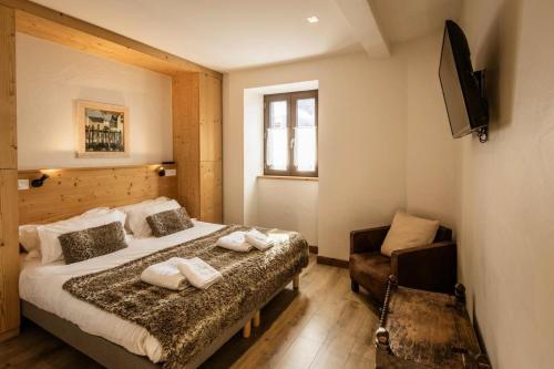 Un dormitorio con una cama y una silla y un televisor. en Résidence Les Etoiles Des Neiges - 4 pièces 6 personnes exposé Ouest MAE-7854, en Valloire