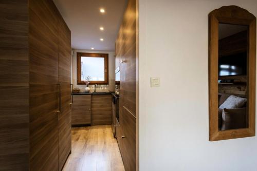 - une cuisine avec des placards en bois et un miroir dans l'établissement Les Chalets D'adrien - 4 pièces duplex 8 personnes 4 exposé Ouest MAE-8204, à Valloire