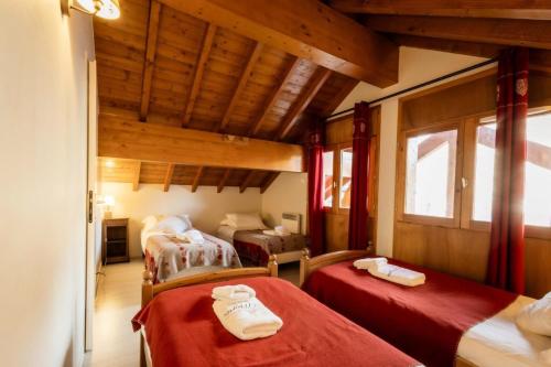 une chambre avec deux lits dans une pièce avec des plafonds en bois dans l'établissement Les Chalets D'adrien - 4 pièces duplex 8 personnes 4 exposé Ouest MAE-8204, à Valloire