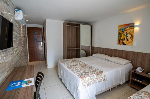 a hotel room with a bed and a table at Bessa Beach Hotel in João Pessoa