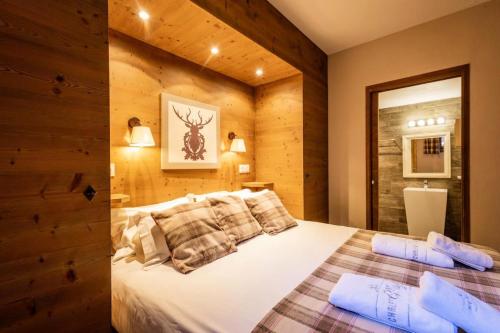 - une chambre avec un lit blanc et un mur en bois dans l'établissement Les Chalets D'adrien - 4 pièces 8 personnes exposé Ouest MAE-8744, à Valloire