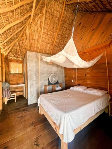 ein Schlafzimmer mit einem Bett mit Moskitonetz in der Unterkunft Ballelita in Zipolite