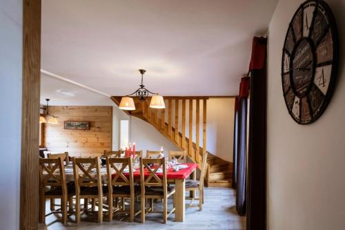 une salle à manger avec une table et une horloge au mur dans l'établissement Les Chalets D'adrien - 5 pièces duplex 10 personnes 4 exposé ouest MAE-8864, à Valloire