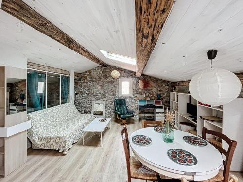 une cuisine et un salon avec une table et des chaises dans l'établissement Charmant appartement dans quartier grand théâtre, à Sète