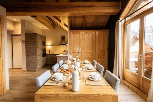 une salle à manger avec une longue table en bois et des chaises dans l'établissement Les Chalets D'adrien - 3 pièces 6 personnes exposé ouest MAE-9374, à Valloire