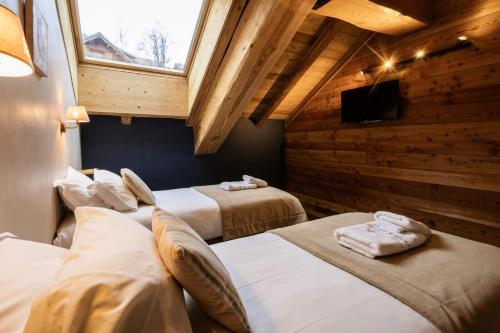 une chambre avec trois lits et une télévision dans un immeuble dans l'établissement Les Chalets D'adrien - 3 pièces 6 personnes exposé ouest MAE-9374, à Valloire