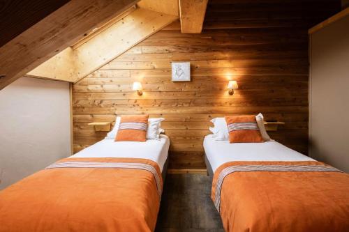 deux lits dans une chambre aux murs en bois dans l'établissement Les Chalets D'adrien - 3 pièces 6 personnes exposé ouest MAE-9384, à Valloire