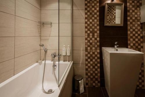 une salle de bain avec une baignoire, une douche et un lavabo dans l'établissement Les Chalets D'adrien - 3 pièces 6 personnes exposé ouest MAE-9384, à Valloire