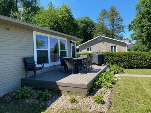 a deck with chairs and a table on a house at Beautiful Torch Lake House with Beach Access home in Rapid City
