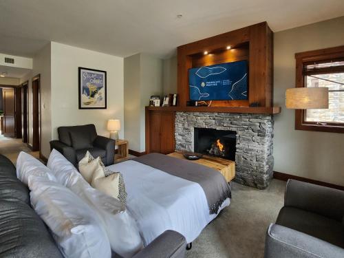 モントランブランにあるTremblant Prestige - Étoile 1510-23のベッドと暖炉のある寝室