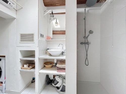 une salle de bain blanche avec un lavabo et une douche dans l'établissement Charmant appartement dans quartier grand théâtre, à Sète