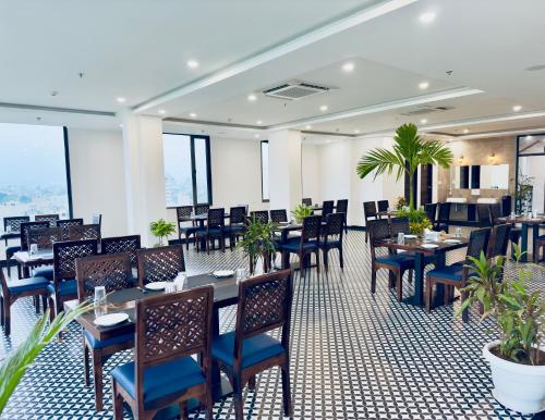 a restaurant with tables and chairs and plants at The Glance inn Udaipur by NAINA STAYCATION - Rooftop swimming pool ! prime location ! most awarded ! big parking ! in Udaipur