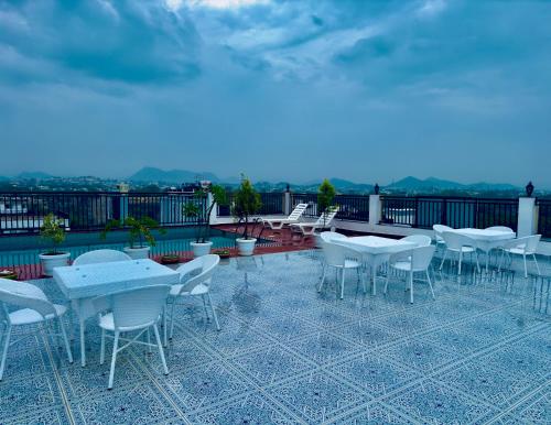 a group of tables and chairs on a roof at The Glance inn Udaipur by NAINA STAYCATION - Rooftop swimming pool ! prime location ! most awarded ! big parking ! in Udaipur