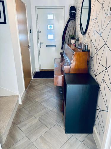 a hallway with a table and a mirror and a door at 4 bed Townhouse with spectacular views 4 miles from Cardiff 10min drive or train journey to city centre in Cardiff