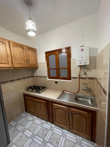 a kitchen with a sink and a stove in it at Apartamentos nuevos in Chefchaouen