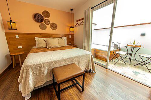 a bedroom with a bed and a large window at La Martina Boutique Hotel in Medellín