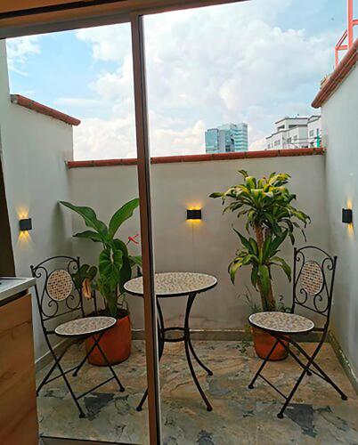 a balcony with two chairs and a table and some plants at La Martina Boutique Hotel in Medellín