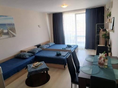 una sala de estar con dos camas y una mesa en Студио Черноморски залив Атия Резорт, en Chernomorets