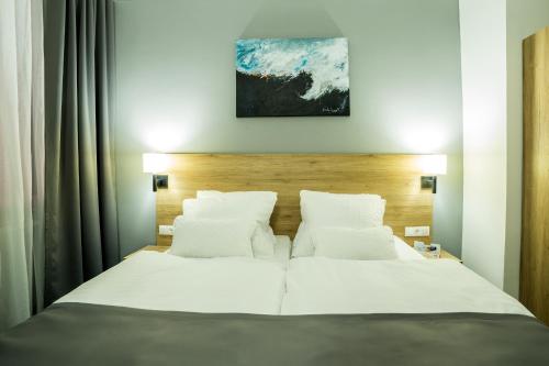 a bedroom with a bed with white sheets and pillows at LivInn by Trotmannia in Dortmund