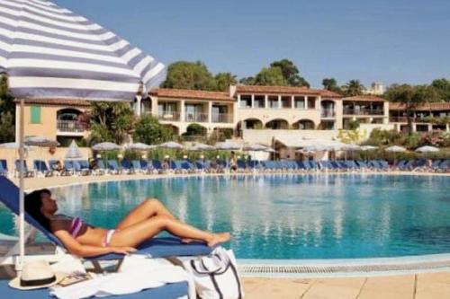 Eine Frau, die auf einem Stuhl neben einem Pool liegt. in der Unterkunft Beautiful Sea View Studio in Grimaud