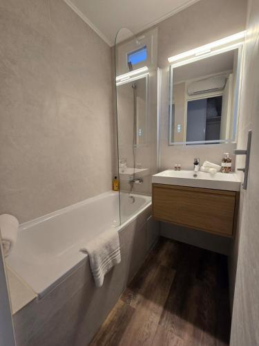 une salle de bain avec une baignoire, un lavabo et un miroir dans l'établissement Beautiful Sea View Studio, à Grimaud