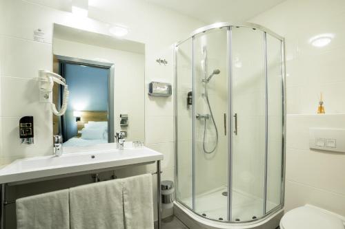 y baño con ducha y lavamanos. en LivInn Hotel, en Dortmund