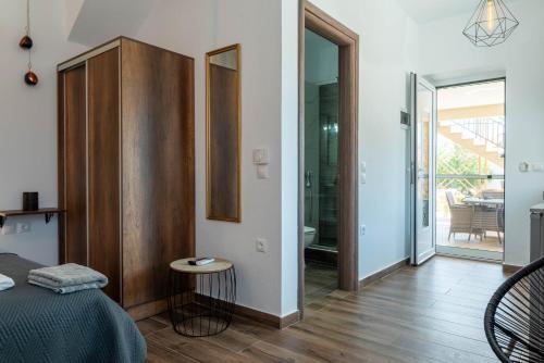 a bedroom with a bed and a table and a balcony at Aigli Luxury Studios in Nea Roda