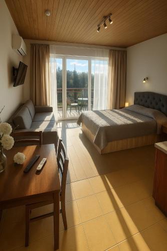 a bedroom with a bed and a table and a couch at Svečių namai Vilma in Šventoji