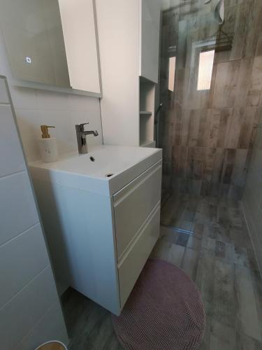 a bathroom with a white sink and a shower at Apartman Sidonija in Križevci