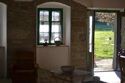 a living room with a table and a window at Posestvo Brida - Brkini Hills by the Lakes in Ilirska Bistrica