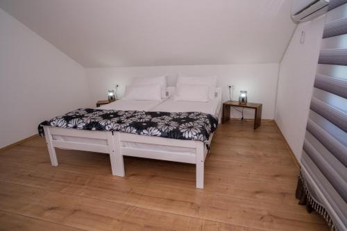 a white bed in a room with a wooden floor at Sarajevo Villa Sunce in Ilijaš