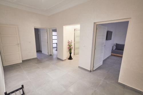 a room with a vase with flowers in it at Family Stay Ourzazate - Deluxe Appartments in Ouarzazate
