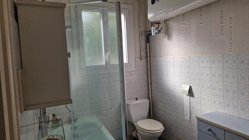 une salle de bain avec toilettes, lavabo et fenêtre dans l'établissement Maison 3 chambres proximité commerce et plage, à L'Aiguillon-la-Presqu'île