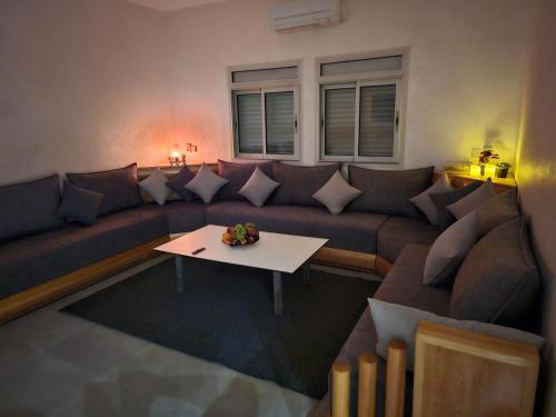 a living room with a couch and a table at Family Stay Ourzazate - Deluxe Appartments in Ouarzazate