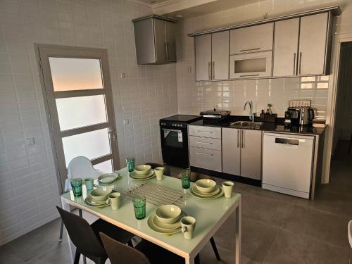 a kitchen with a table with cups and dishes on it at Family Stay Ourzazate - Deluxe Appartments in Ouarzazate