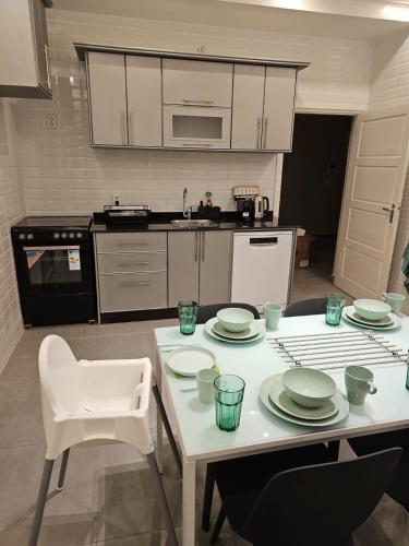 a kitchen with a table with plates on it at Family Stay Ourzazate - Deluxe Appartments in Ouarzazate